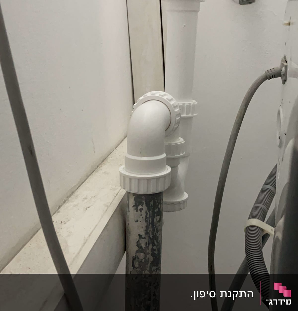 צינורות פלסטיק לבנים מחוברים לקיר